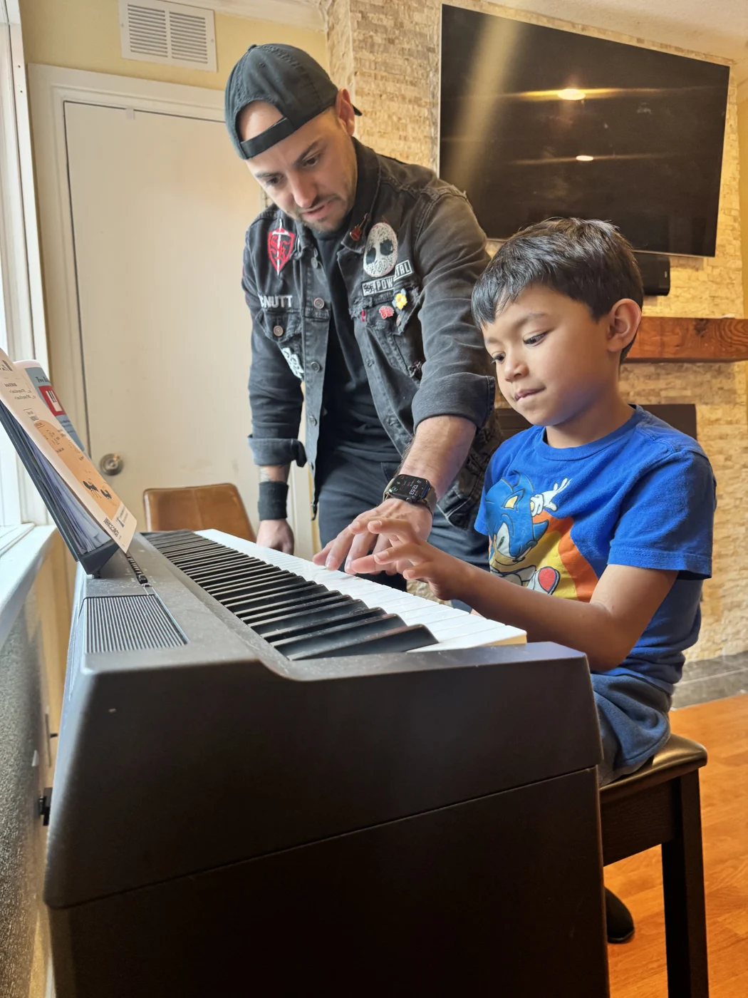 Mr. Garrett guiding a young student at a piano